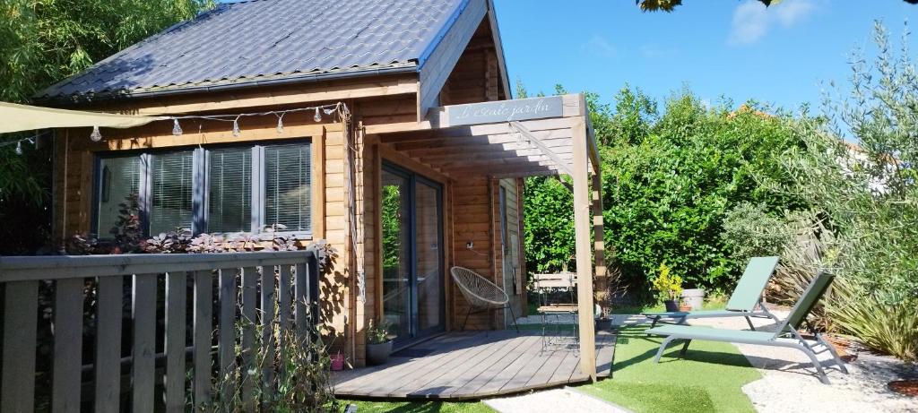 a small cabin with a wooden deck and a fence at L escale jardin in Boussay