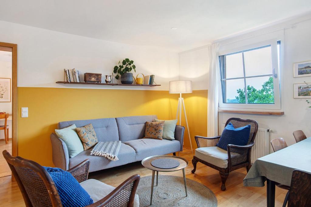 un soggiorno con un divano e sedie blu di Ferienwohnung Fellagrün a Unterbierbronnen