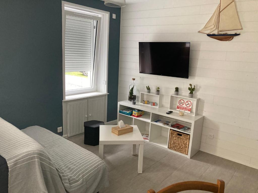 a bedroom with a bed and a tv on a wall at Ty Ar Pesketour in Penmarch