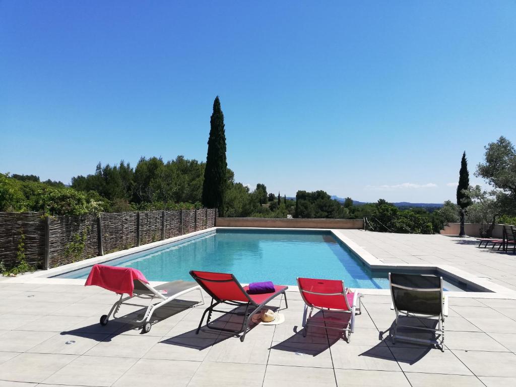 un groupe de chaises assises à côté d'une piscine dans l'établissement Les Garrigues de la Vallée des Baux, à Paradou
