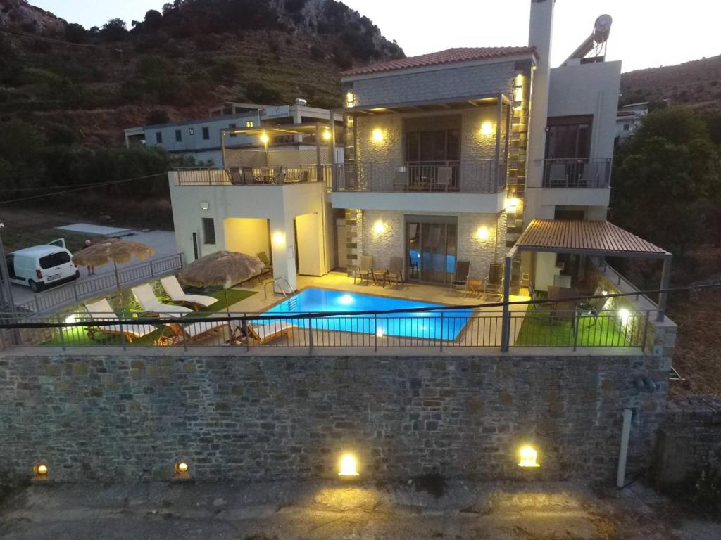 a villa with a swimming pool at night at Villa Kali Sykia in Kalí Sikéa