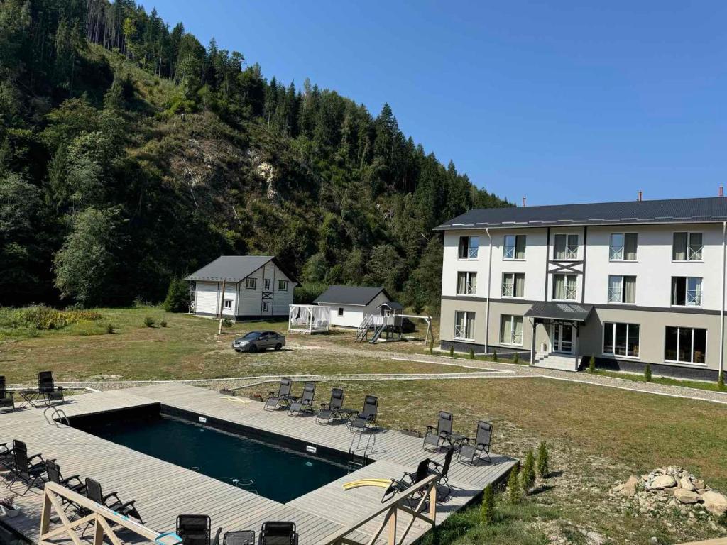 a large building with a swimming pool next to a building at Відпочинковий комплекс Біла Кобила in Verkhovyna