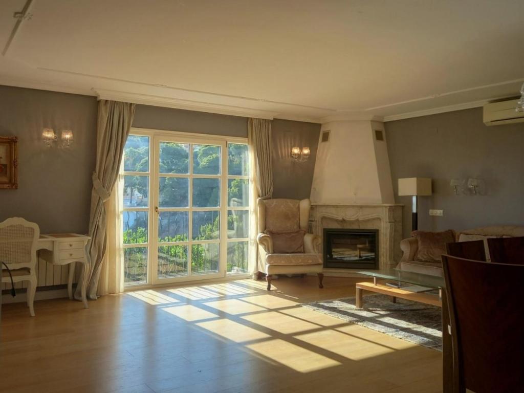 un soggiorno con camino e una grande finestra di Villa Anna-Altea ad Altea
