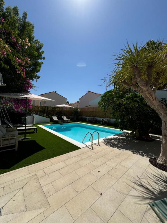 ein Pool im Garten mit einem Baum in der Unterkunft Magnífico Timón 8 in Pasito Blanco