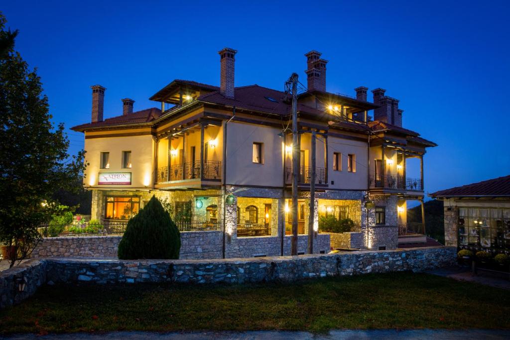 uma casa grande com luzes acesas à noite em Atrion Highland Hotel em Elatochori