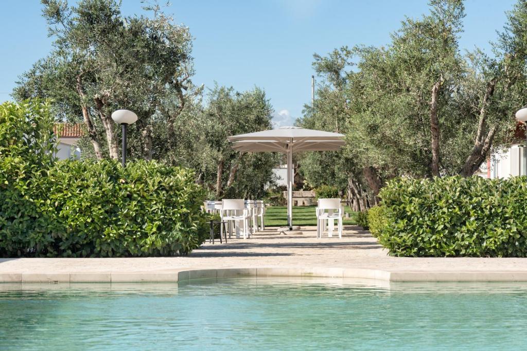 a pool with a table and an umbrella and chairs at Agriturismo Panacea in Santa Cesarea Terme