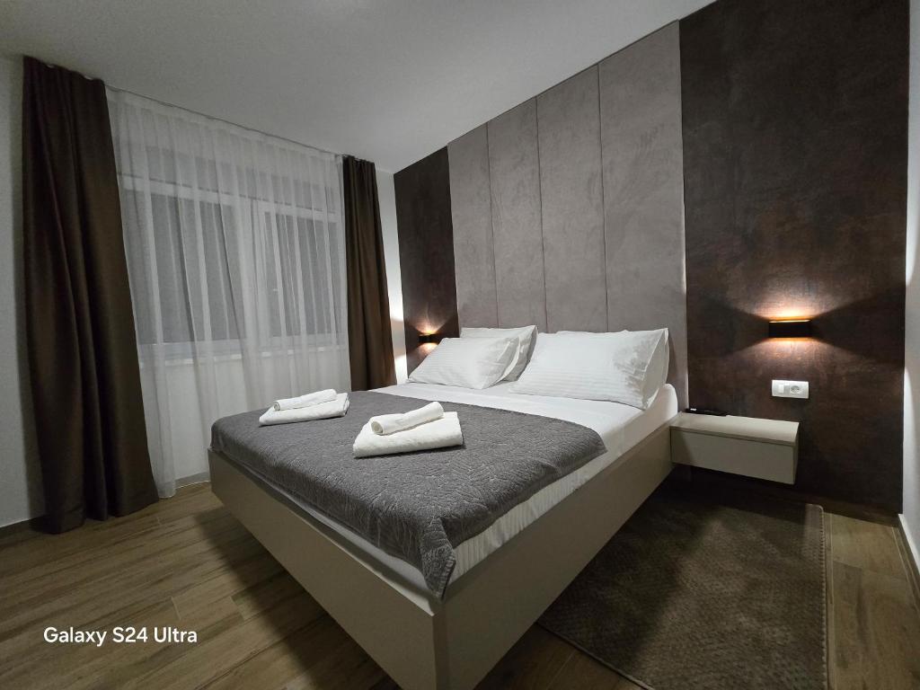 奥西耶克Apartman FIŠBAH 6 self CHECK-IN, FREE PRIVATE PARKING的一间卧室，床上有两条毛巾