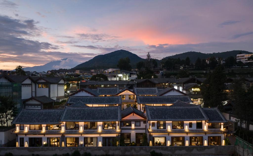 a view of a building with mountains in the background at La Maison Hotel - Lijiang in Lijiang