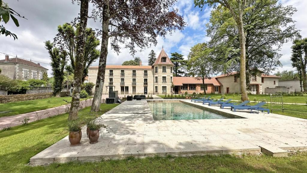 a large building with a pool in front of it at Gite du manoir des perrieres in Rochechouart