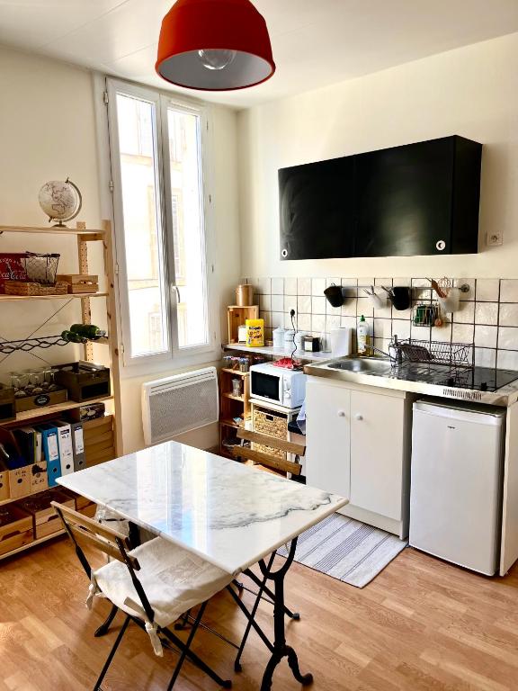 une cuisine avec une table et un comptoir dans l'établissement Studio lumineux quartier Baille, à Marseille