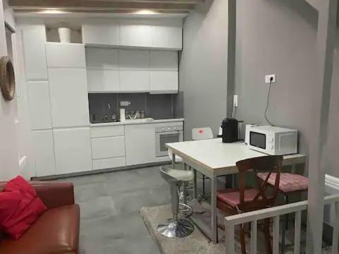 - une cuisine blanche avec une table et un four micro-ondes dans l'établissement Duplex au Sentier secret au cœur de Paris, à Paris