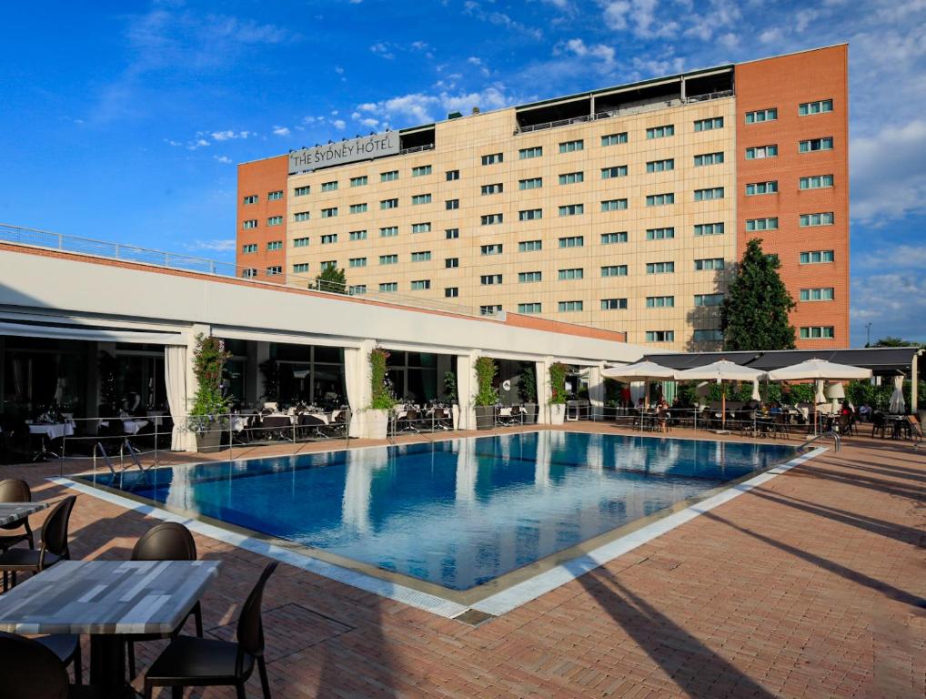 a hotel with a swimming pool in front of a building at The Sydney Hotel in Bologna
