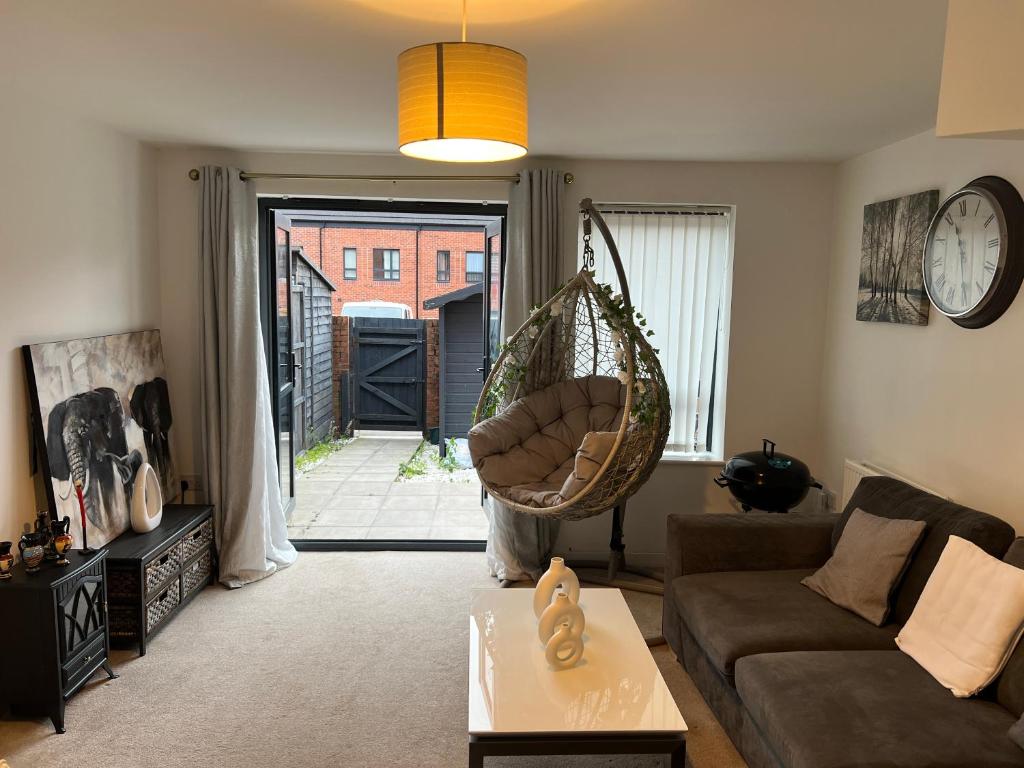 a living room with a couch and a hanging swing at X marina breeze x in Swansea