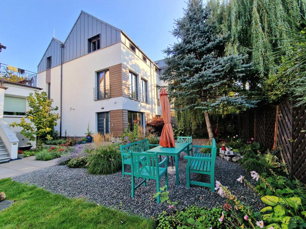 a garden with two chairs and a table with an umbrella at La Jaguara artistic house in the center of Gdansk in Gdańsk