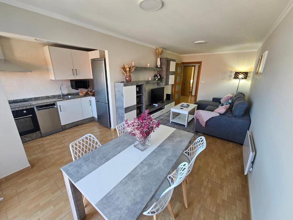 Una cocina y una sala de estar con mesa y sillas. en Apartamento Nara Playa, en Boiro