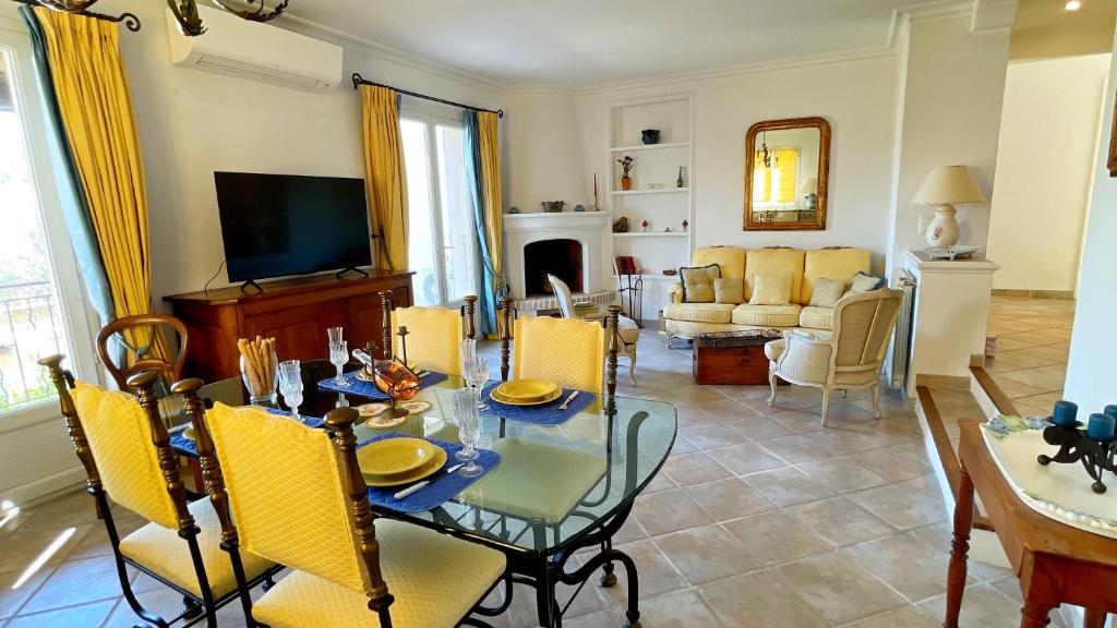 un salon avec une table et des chaises jaunes dans l'établissement Villa Les Cistes, à La Colle-sur-Loup