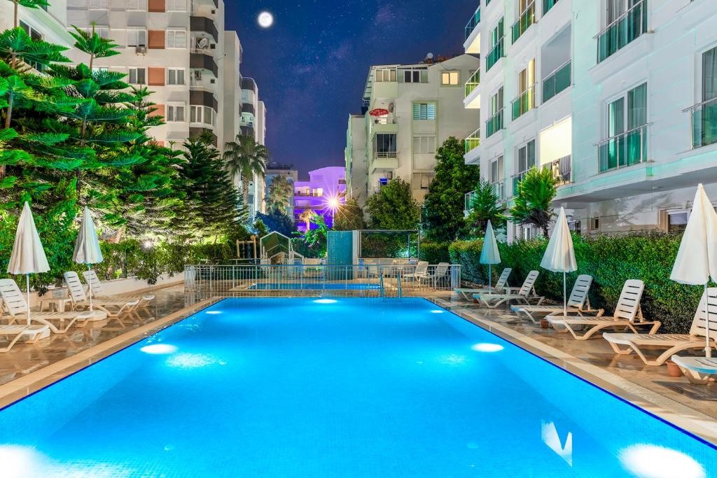 a swimming pool at night with chairs and umbrellas at The Suites in Antalya