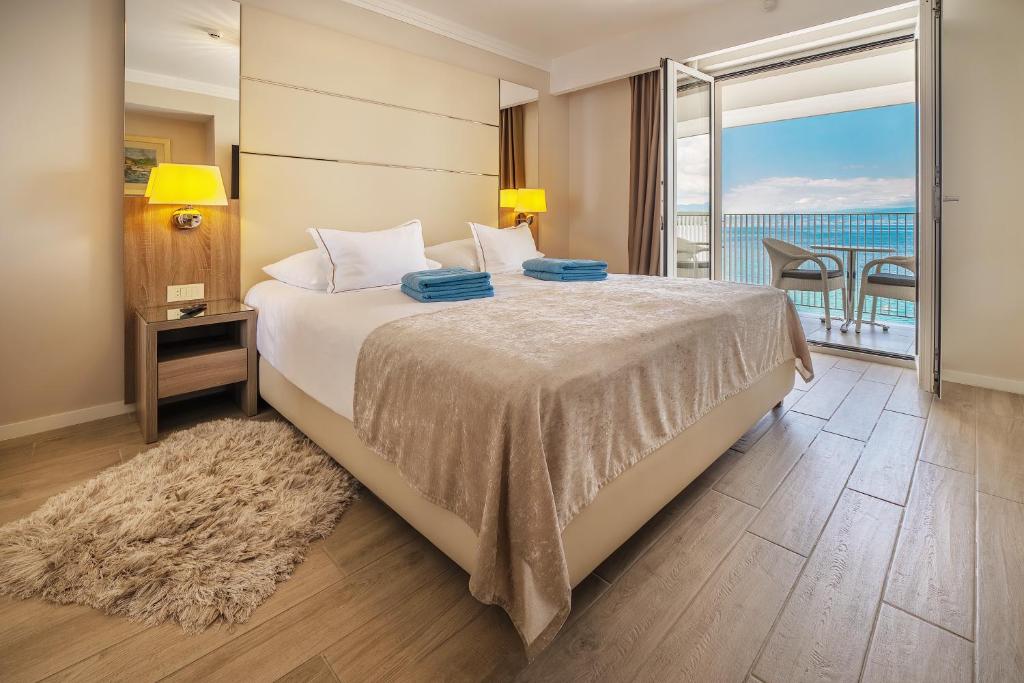 sypialnia z łóżkiem i widokiem na ocean w obiekcie Hotel Vila Rova w mieście Malinska