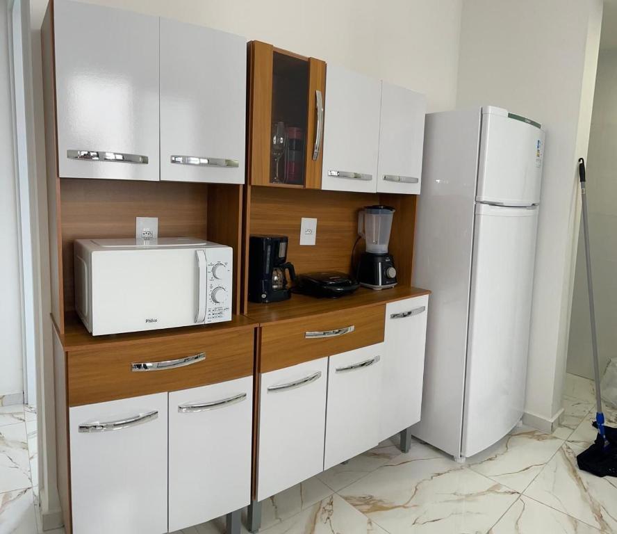 une cuisine avec des armoires blanches et un réfrigérateur dans l'établissement S3 - Lindo Apartamento em região central, à Foz do Iguaçu