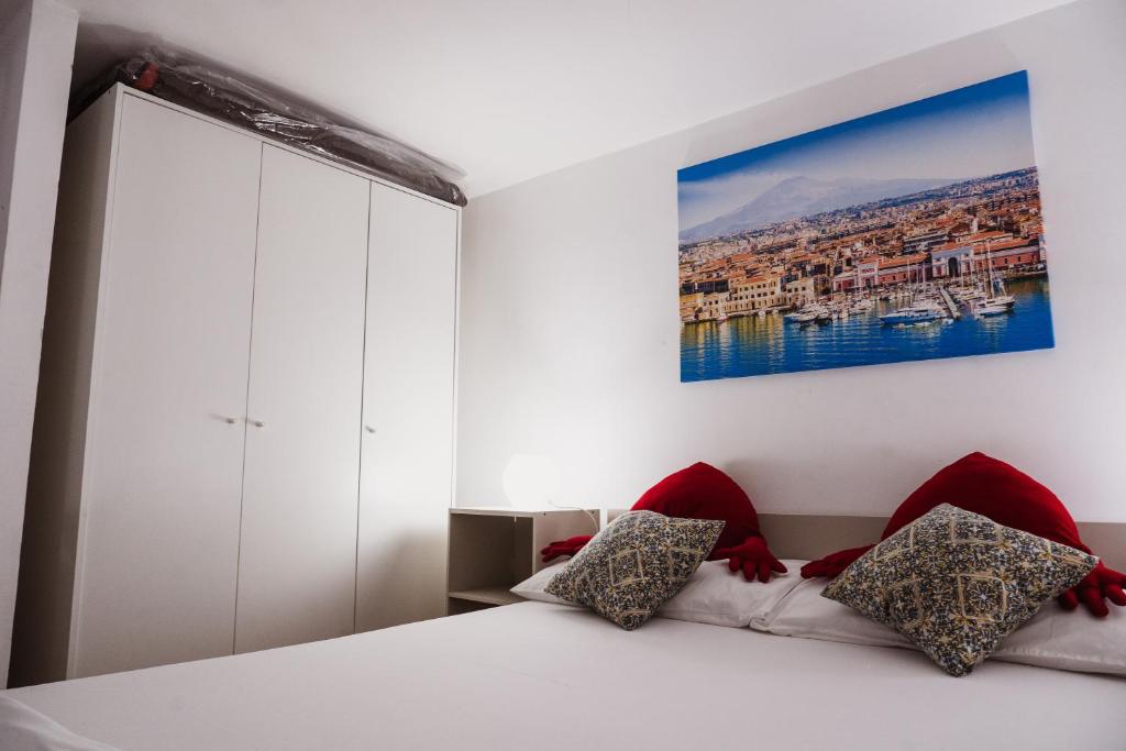 a bedroom with a bed and a painting on the wall at Perla Azzurra in Catania