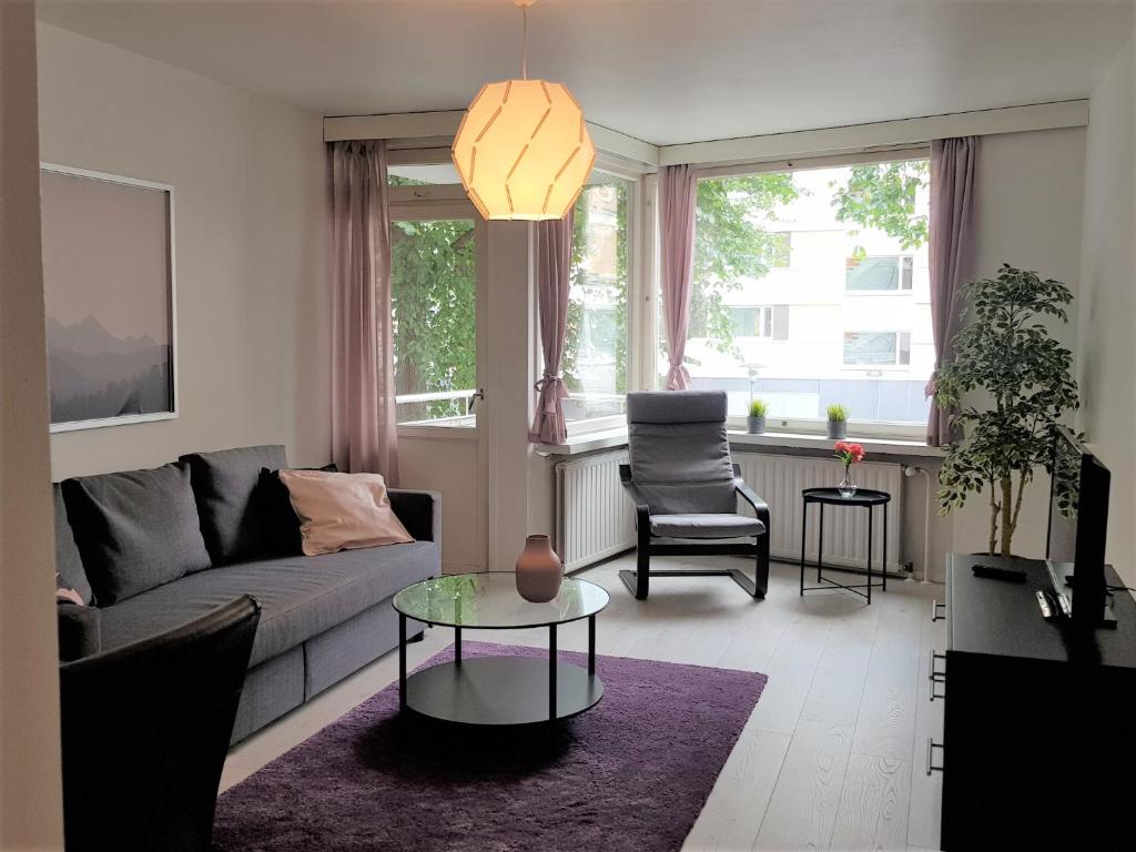un soggiorno con un divano e un tavolo di Kotimaailma Apartments - 1BR in city center of Turku a Turku