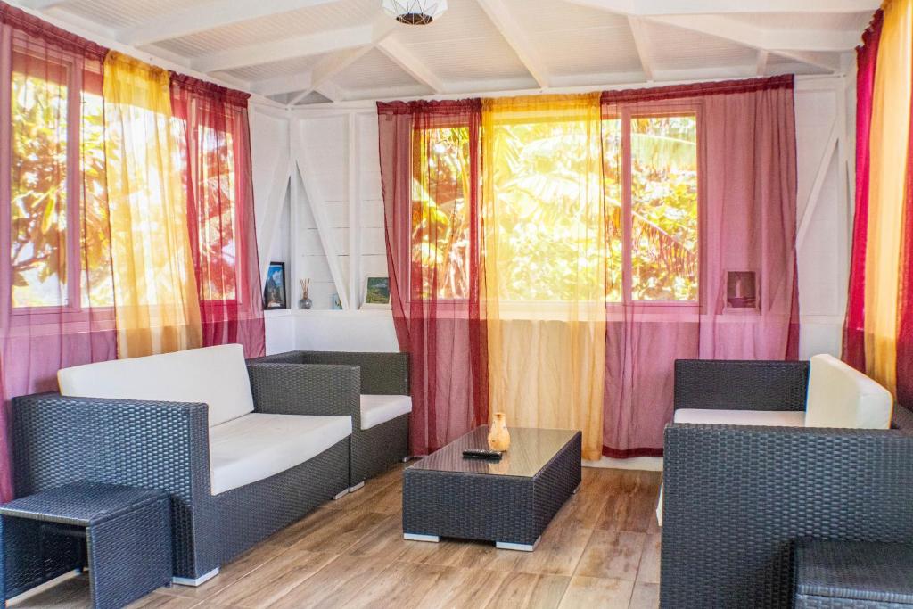 a living room with colorful curtains and chairs at Montete Cottage Hilltop Villa with Beautiful Estate Garden in Choiseul