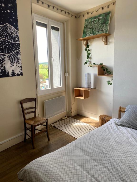 a bedroom with a bed and a chair and a window at Les Sainfoins, Idéal voyageurs Pro in Villeneuve-sur-Yonne
