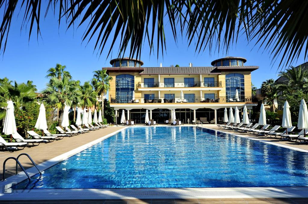un complexe avec une piscine, des chaises et un bâtiment dans l'établissement Villa Augusto Boutique Hotel & SPA, à Konaklı