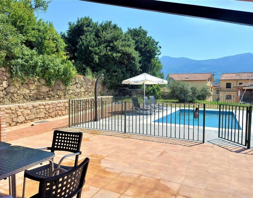 a patio with a fence and a swimming pool at Casa Rural El Barranco in Mombeltrán