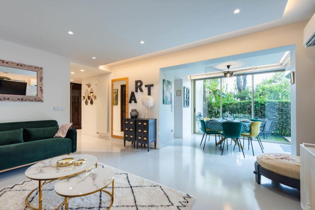 un salon avec un canapé vert et une table dans l'établissement RARE! 2-Br with Pools Beach Access Private Parking, à Cannes