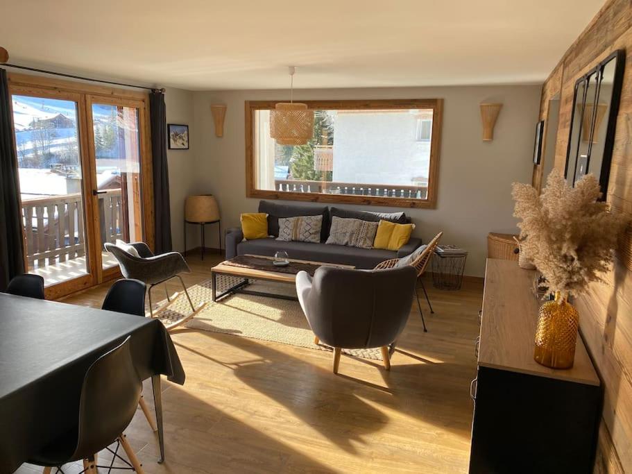 un salon avec un canapé et des chaises dans l'établissement Appartement vieux Bois rénové avec terrasse, à La Clusaz