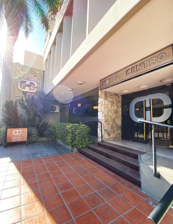 Un vestíbulo de un hotel con escaleras y palmeras. en Hotel Centro, en Santiago del Estero