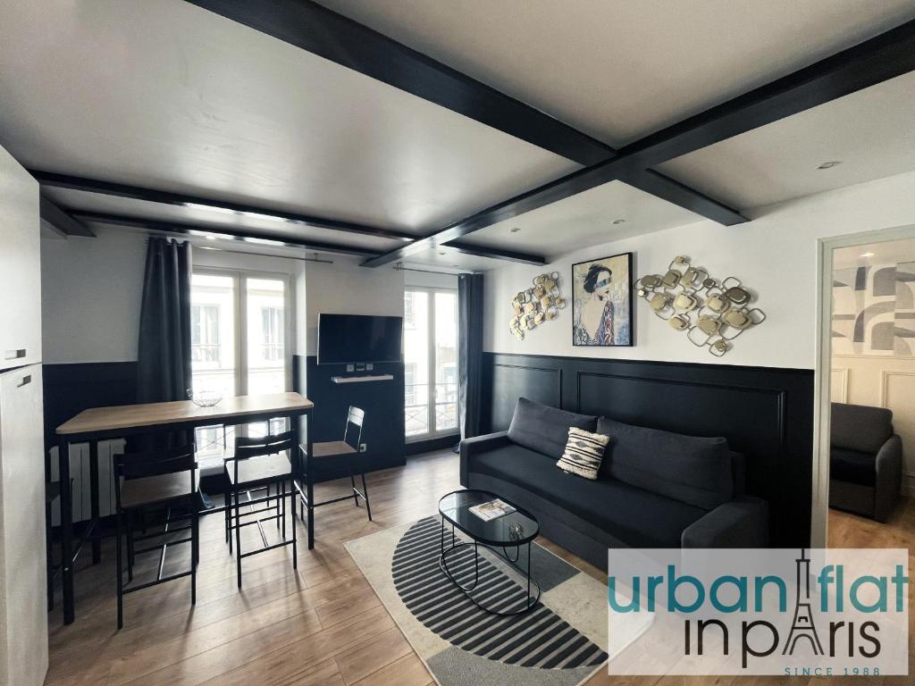 un salon avec un canapé et une table dans l'établissement Urban Flat 13 - Pretty 2 Bedroom Parisian Flat, à Paris