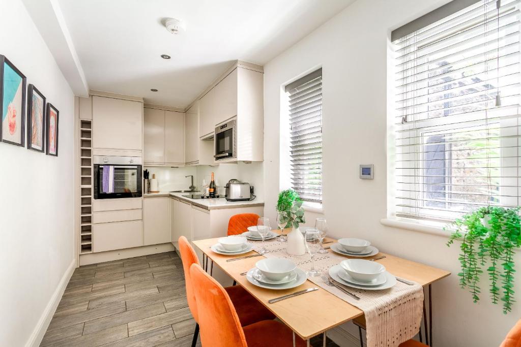 a kitchen and dining room with a table and chairs at Cozy Kingfisher - 2-Bed Bungalow in Brighton near the Beach With Free WiFi & Terrace by Kozmo Properties in Brighton & Hove