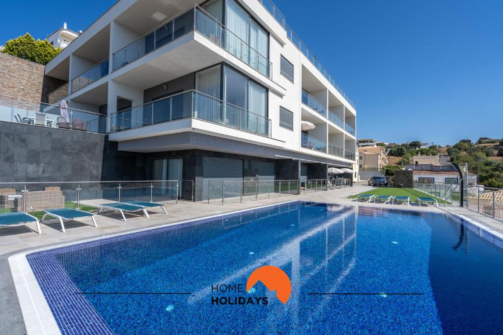 アルブフェイラにある#235 New City by Home Holidaysの建物の前にプールがあるホテル