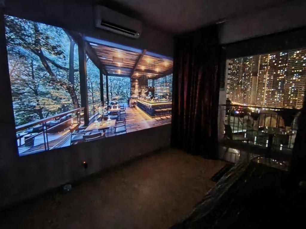 ein Raum mit einem großen Bildschirm mit Blick auf ein Gebäude in der Unterkunft Private Cinema and Jacuzzi at Pertama Residency in Kuala Lumpur