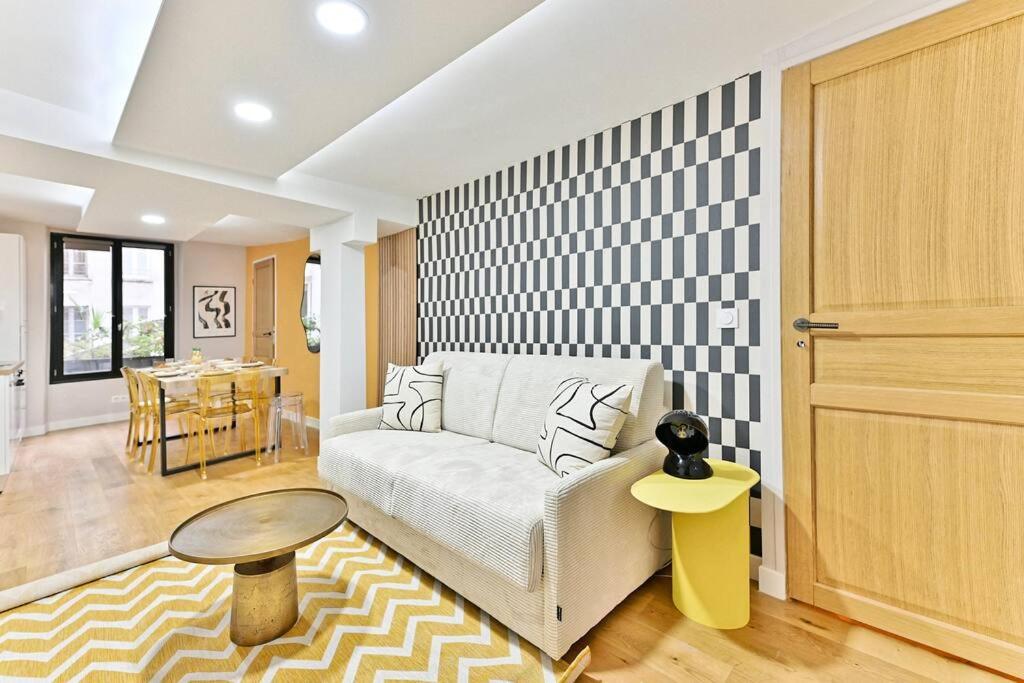 un salon avec un canapé et une table dans l'établissement Appartement 3 chambres Paris 2ème - II, à Paris