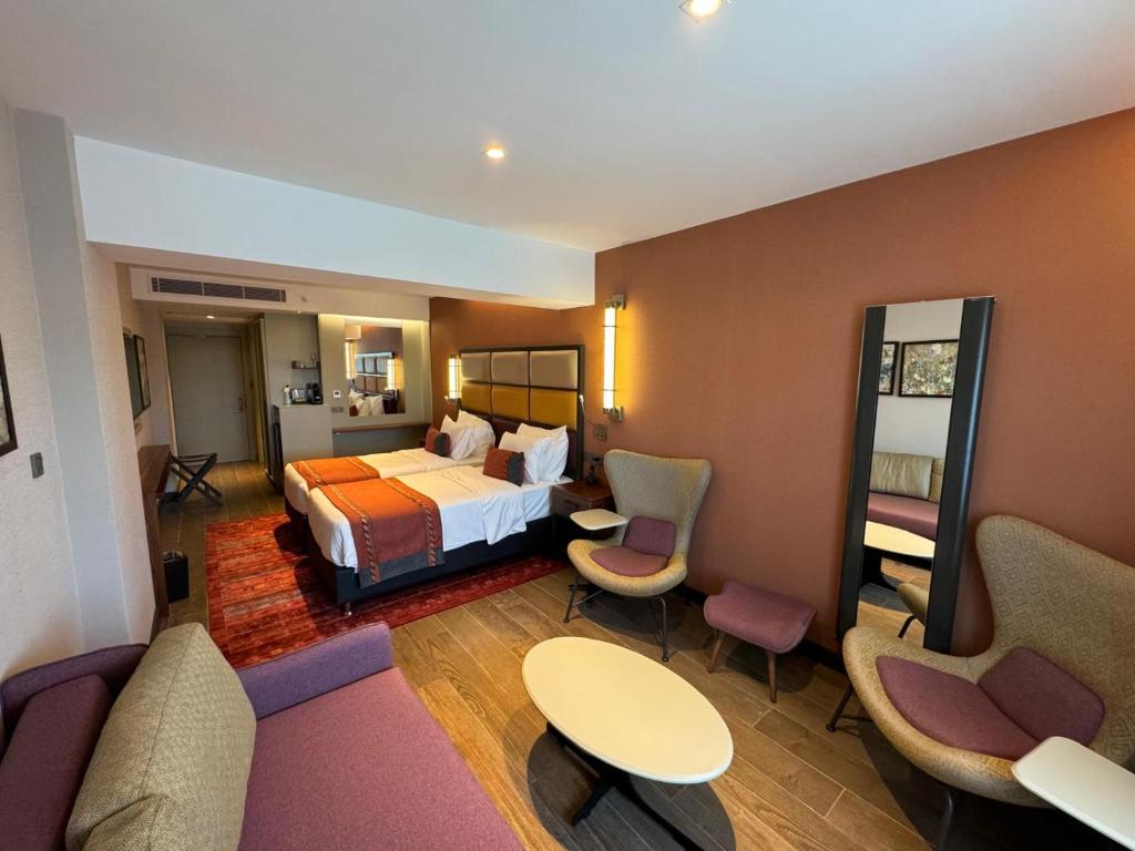 a hotel room with a bed and tables and chairs at Sile Gonen Hotel in Şile