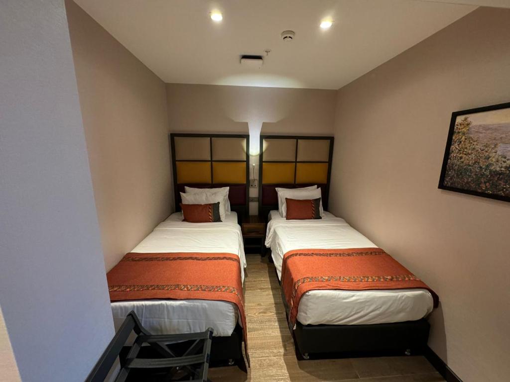 two twin beds in a small room with at Sile Gonen Hotel in Şile