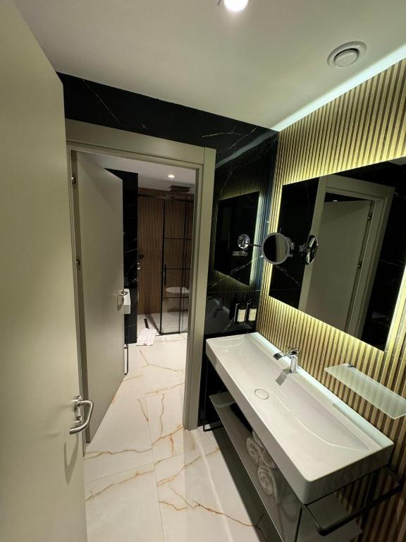 a bathroom with a sink and a mirror at Sile Gonen Hotel in Şile