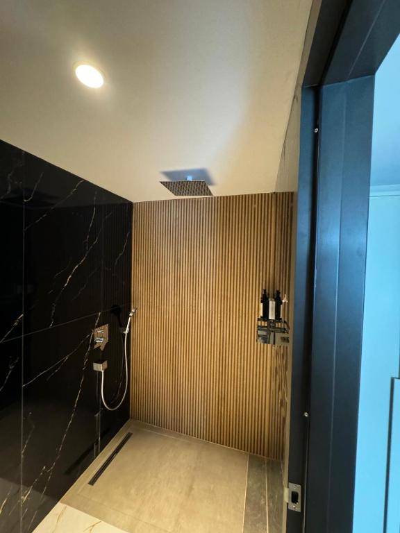 a bathroom with a shower with black and brown stripes at Sile Gonen Hotel in Şile