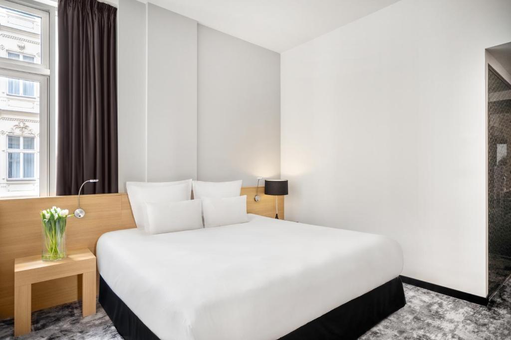 a large white bed in a hotel room at Nemzeti Hotel Budapest - MGallery Collection in Budapest