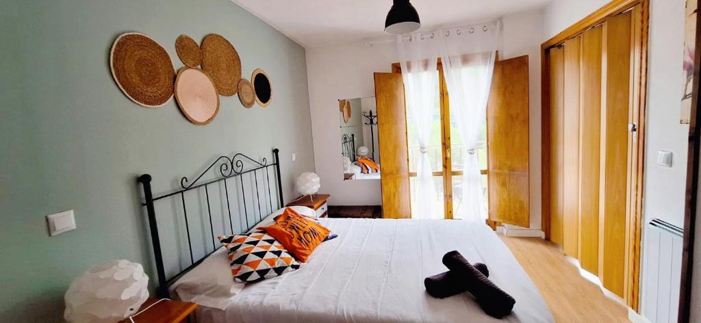 ein Schlafzimmer mit einem Bett mit zwei schwarzen Schuhen darauf in der Unterkunft Mirador de Bergosa VU-HUESCA-20-111 in Castiello de Jaca