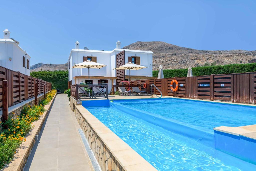 eine Villa mit Swimmingpool vor einem Haus in der Unterkunft Lindos Ruby in Lindos