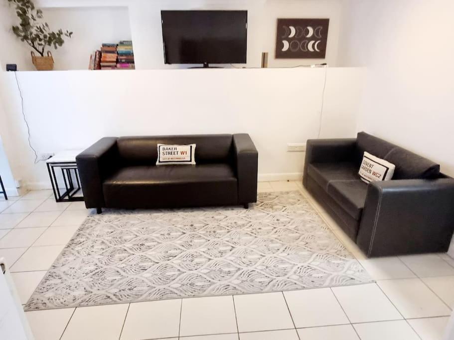 two black leather couches sitting in a living room at Evo B - 1 Bedroom Flat 2 Min Walk to Station & Town Centre in Gravesend