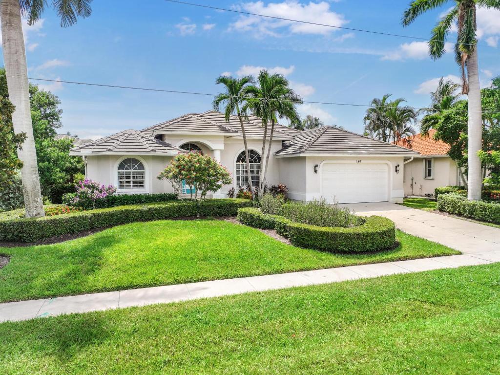 a house with palm trees and a lawn at W exposure waterfront home with pool and dock in Marco Island