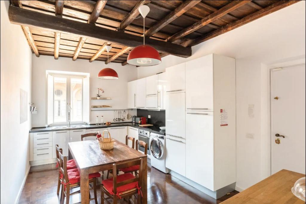 kuchnia z białymi szafkami i stołem z krzesłami w obiekcie Residenza Torre Vecchiarelli - apt 4 w Rzymie