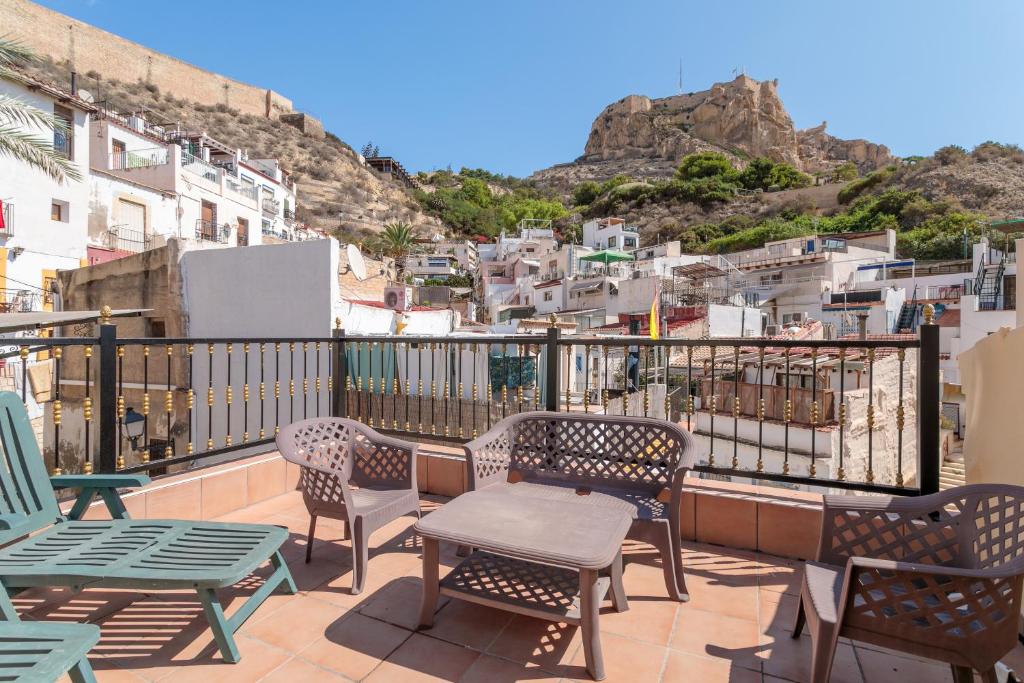 eine Terrasse mit Stühlen und Tischen auf dem Balkon in der Unterkunft La torre in Alicante