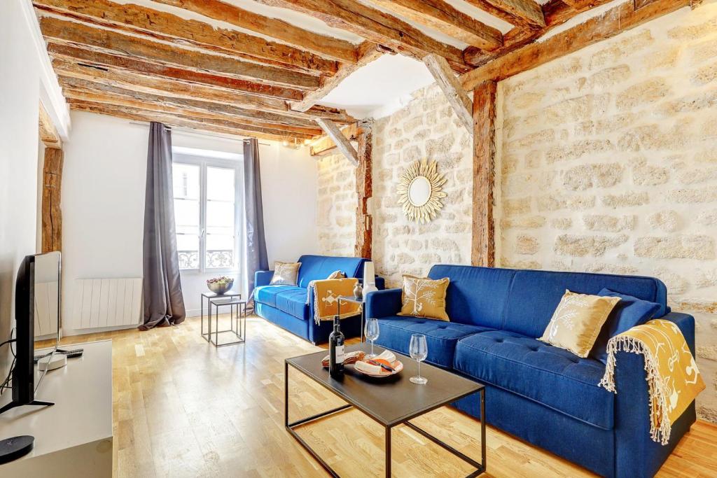 un salon avec un canapé bleu et une télévision dans l'établissement Bluestay 282 - Superbe appartement avec terrasse, à Paris