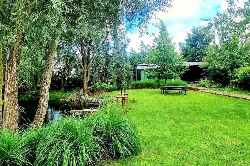 a park with a bench and a pond at Garden room in green surroundings, sleeps 2 in Roeselare
